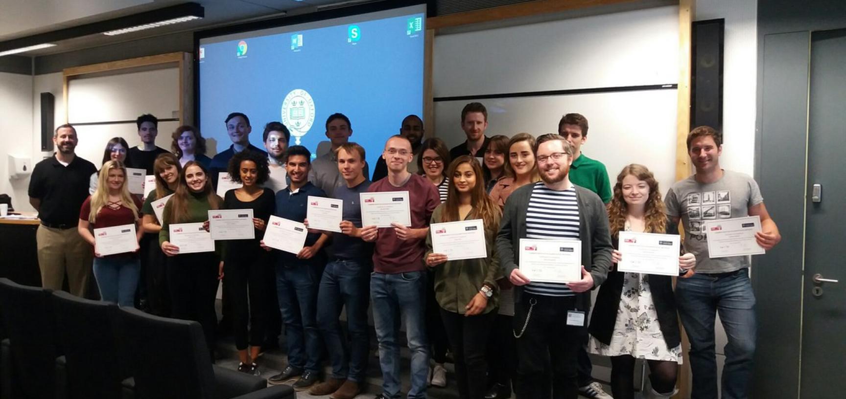 Summer Institute students posing for photo while holding their obtained certificates 