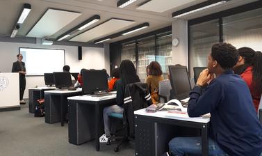 Q-Step lecturer standing in front of classroom with Target Oxbridge participants 