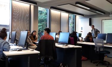 UNIQ students sitting in computer lab room discussing in small groups