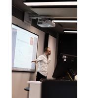 Lecturer standing in front of projector explaining plot